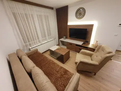 a living room with a couch and chairs and a television at Iznad oblaka A6 in Kopaonik