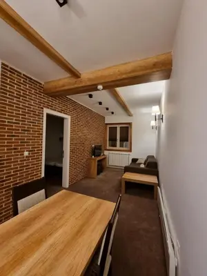 a living room with a wooden table and a couch at Apartman Zupa 112 in Kopaonik