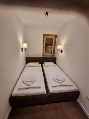 a bedroom with two beds in a room with a mirror at Apartman Zupa 112 in Kopaonik