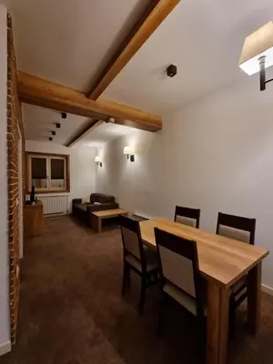 a living room with a table and chairs and a couch at Apartman Zupa 112 in Kopaonik