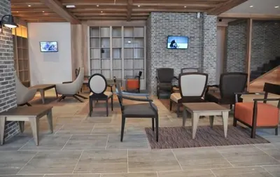 a lobby with chairs and tables in a building at Apartman Zupa 112 in Kopaonik