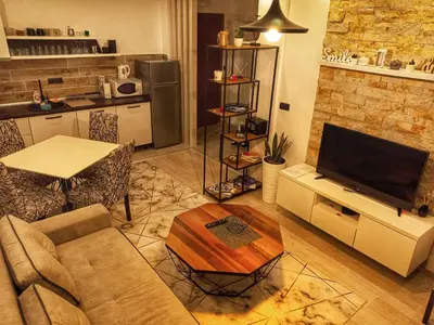 a living room with a couch and a tv and a table at Milmari Resort N56 Kopaonik wellnes&spa in Kopaonik