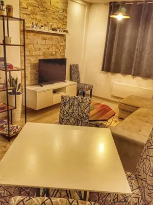 a living room with a table and a tv at Milmari Resort N56 Kopaonik wellnes&spa in Kopaonik