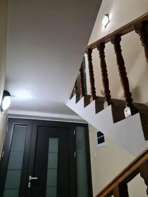 a staircase leading up to a black door with a stair light at Grey & Sunny Apartments Zaječar in Zaječar