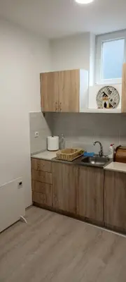 a kitchen with wooden cabinets and a sink and a window at Apartman Bane in Soko Banja