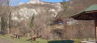 a group of park benches in front of a mountain at Apartman Bane in Soko Banja