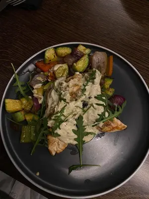a plate of food with meat and vegetables on a table at Pegaz114 in Vrnjačka Banja