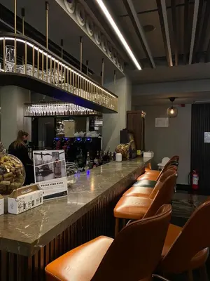 a bar with brown leather stools in a restaurant at Pegaz114 in Vrnjačka Banja