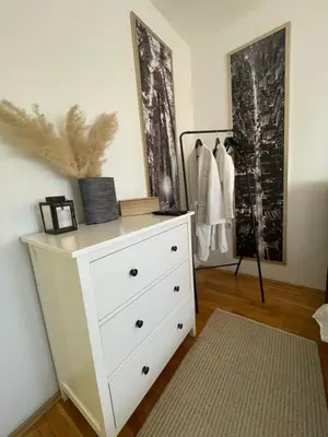 a white dresser in a room with a dresser at Charme apartman in Kruševac