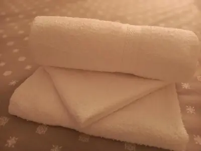 a stack of white towels on a table at Charme apartman in Kruševac