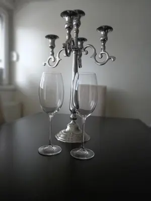 two wine glasses and a candlestick on a table at Charme apartman in Kruševac