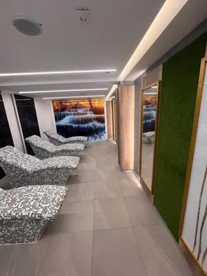 a row of chairs in a hallway with green walls at PresidentKop LUX Wellness & SPA Apartments in Kopaonik