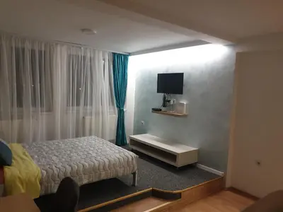 a bedroom with a bed and a television in it at City center apartment 2 in Niš