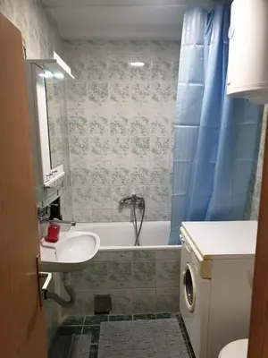 a bathroom with a sink and a tub and a toilet at City center apartment 2 in Niš