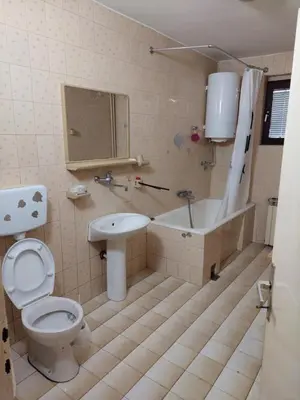 a bathroom with a toilet and a tub and a sink at Hills Apartment in Niš