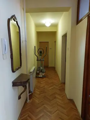 a hallway with a mirror on the wall and a sink at Hills Apartment in Niš