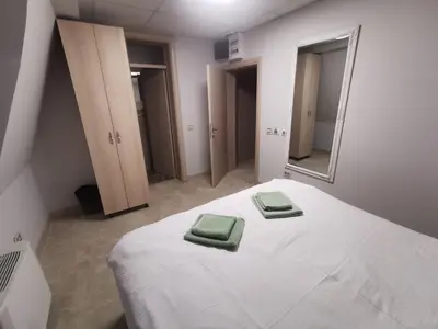 a bedroom with a bed with two green towels on it at City SMART in Niš