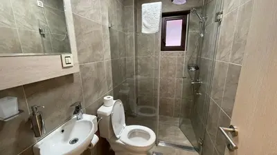 a bathroom with a toilet and a sink and a shower at City SMART in Niš