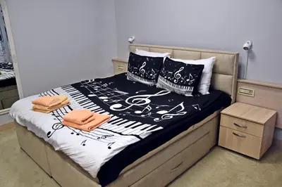 a bed with black and white sheets and pillows at City SMART in Niš