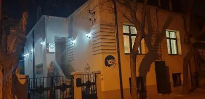 a building with a fence and a tree in front of it at City SMART in Niš
