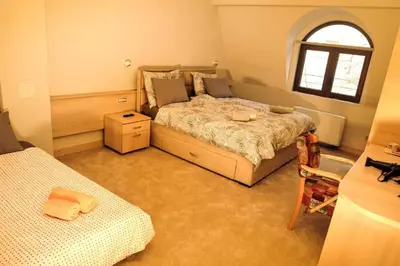 a bedroom with a bed and a chair and a window at City SMART in Niš