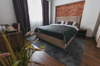a bedroom with a bed and a brick wall at City Centar House in Niš