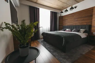 a bedroom with a bed and a table with a potted plant at City Centar House in Niš