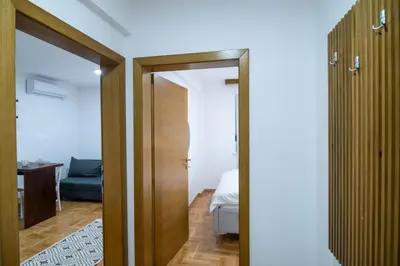 a hallway with a door leading to a bedroom at Visnja Aparmtani in Vrnjačka Banja