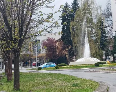 a blue car parked in front of a fountain at Visnja Aparmtani in Vrnjačka Banja