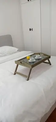 a coffee table sitting on top of a bed at Visnja Aparmtani in Vrnjačka Banja