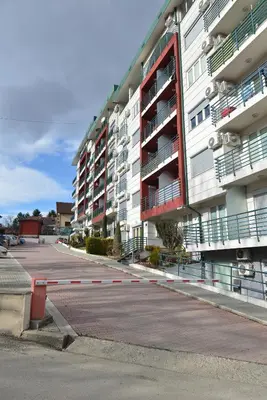 an empty street in front of a large apartment building at Studio apartman Zvezdana Noć in Vrnjačka Banja
