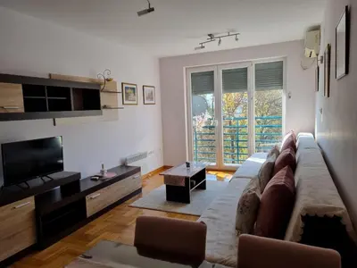 a living room with a couch and a television at Studio apartman Zvezdana Noć in Vrnjačka Banja
