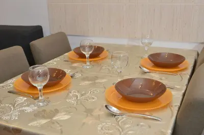 a table with plates and wine glasses on it at Studio apartman Zvezdana Noć in Vrnjačka Banja