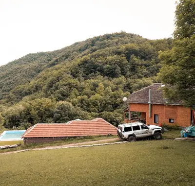 a truck parked in front of a house with a mountain at Jaćimov Konak in Pirot