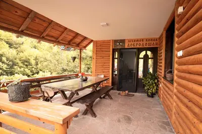 a patio with a table and benches on a porch at Jaćimov Konak in Pirot