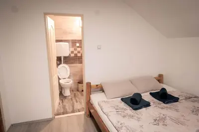 a bedroom with a bed with two black hats on it at Jaćimov Konak in Pirot