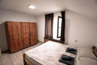 a bedroom with a bed and a wooden cabinet at Jaćimov Konak in Pirot