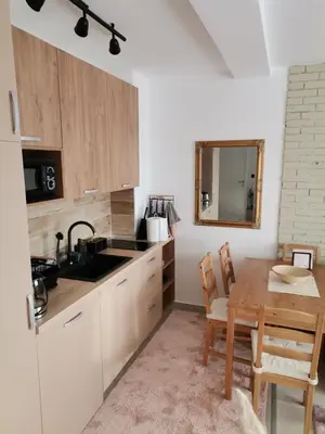 a kitchen with a wooden table and a sink and a dining room at Apartman N101, Milmari, Kopaonik in Kopaonik