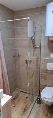 a shower with a glass door in a bathroom at Apartman N101, Milmari, Kopaonik in Kopaonik