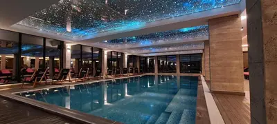 a swimming pool in a building with a star ceiling at Apartman N101, Milmari, Kopaonik in Kopaonik