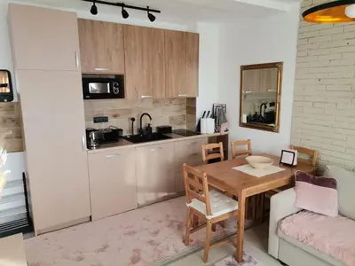 a kitchen with a wooden table and a dining room at Apartman N101, Milmari, Kopaonik in Kopaonik