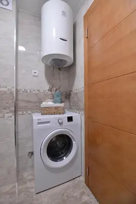 a laundry room with a washing machine and a light at Apartman LUMI in Vrnjačka Banja