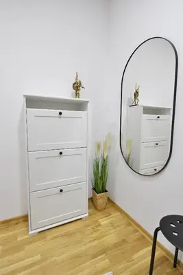 a white dresser in a room with a mirror at Apartman LUMI in Vrnjačka Banja