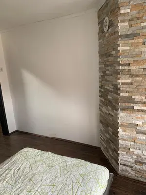 a bedroom with a brick wall and a bed at Aleksinac Centar in Aleksinac