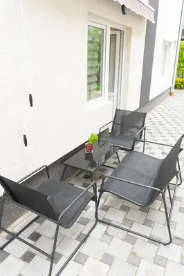 three black chairs and a table on a patio at Sobe Jovan in Soko Banja
