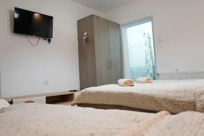 a bedroom with two beds and a tv on the wall at Sobe Jovan in Soko Banja