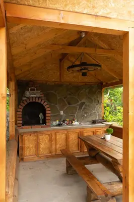 an outdoor kitchen with a table and a stone oven at Sobe Jovan in Soko Banja