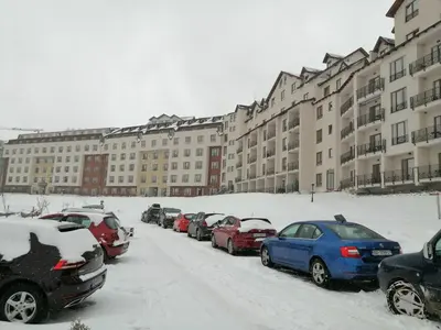 a row of cars parked in a parking lot covered in snow at HUSKY Milmari in Kopaonik