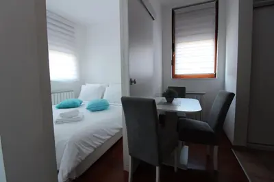 a bedroom with a bed and a table and chairs at Pegaz009**** in Vrnjačka Banja