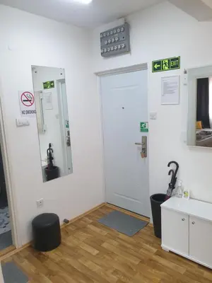 a bathroom with a white door and a sink at Despot Apartmani Niš in Niš